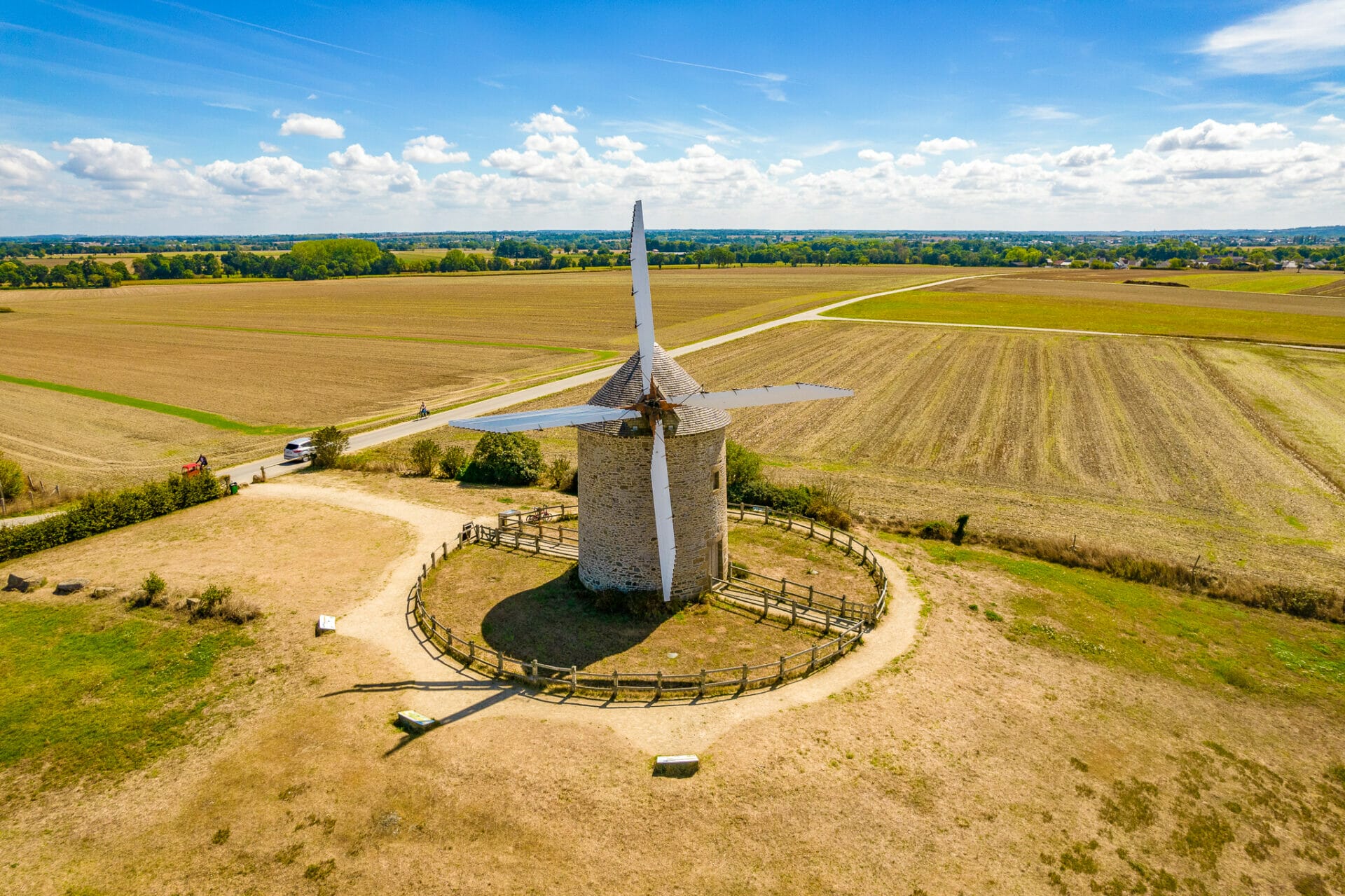 Aerial photo of Moidrey windmill atop golden fields near Mont Saint Michel