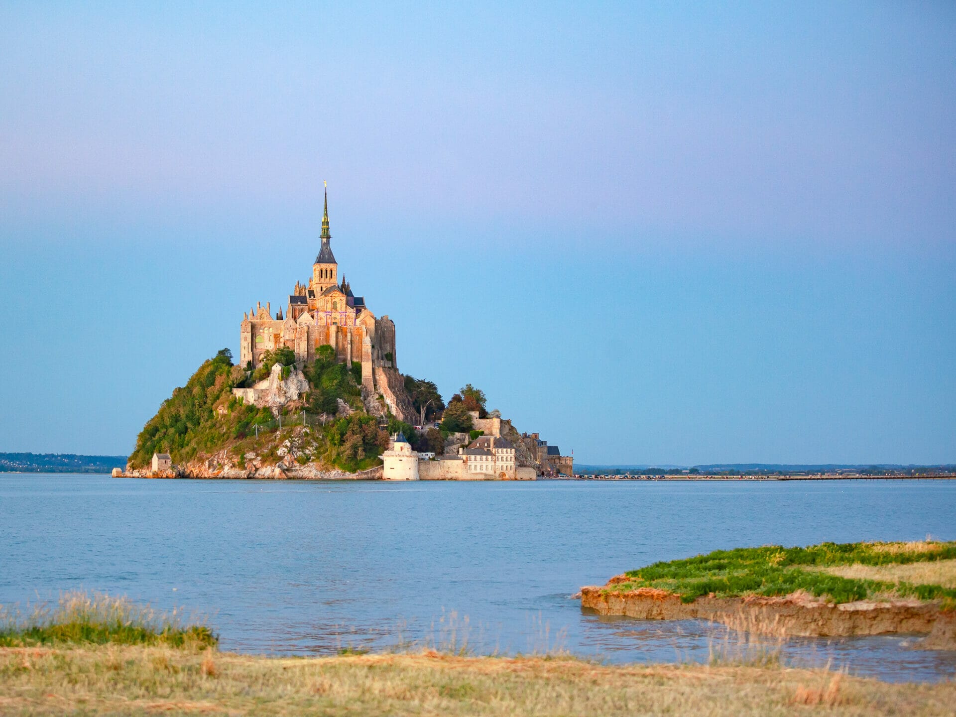 Mont Saint Michel during high tide seen from the marshlands at sunset